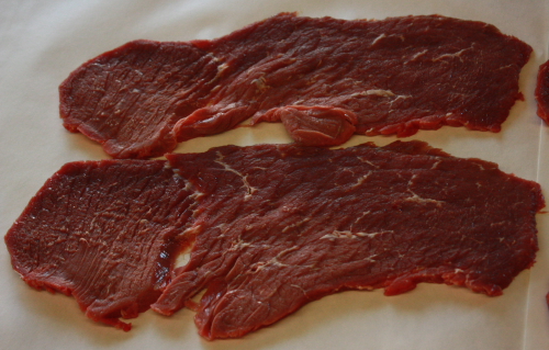 Sliced beef top round (1/4 inch thick) used to make beef jerky.