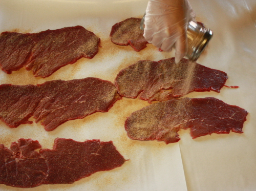 Sprinkling the Jerky Seasoning on the sliced beef top round.  Make sure to sprinkle the jerky seasoning on both sides of the meat.  Sprinkle to taste.  It might take some experimenting to find the exact amount to use for your personal taste.