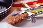 Photo showing how to correctly use a meat thermometer with a hamburger patty.